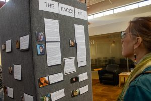 Owens Community College adjunct professor Judy Mathews views the Faces Of exhibit in the Heritage Hall lounge area.