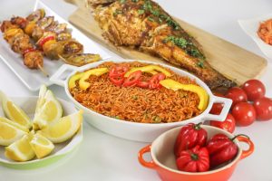 A dinner spread of African Fried Fish and Jollof Rice from Keesha's Kitchen; retrievable from Unsplash.