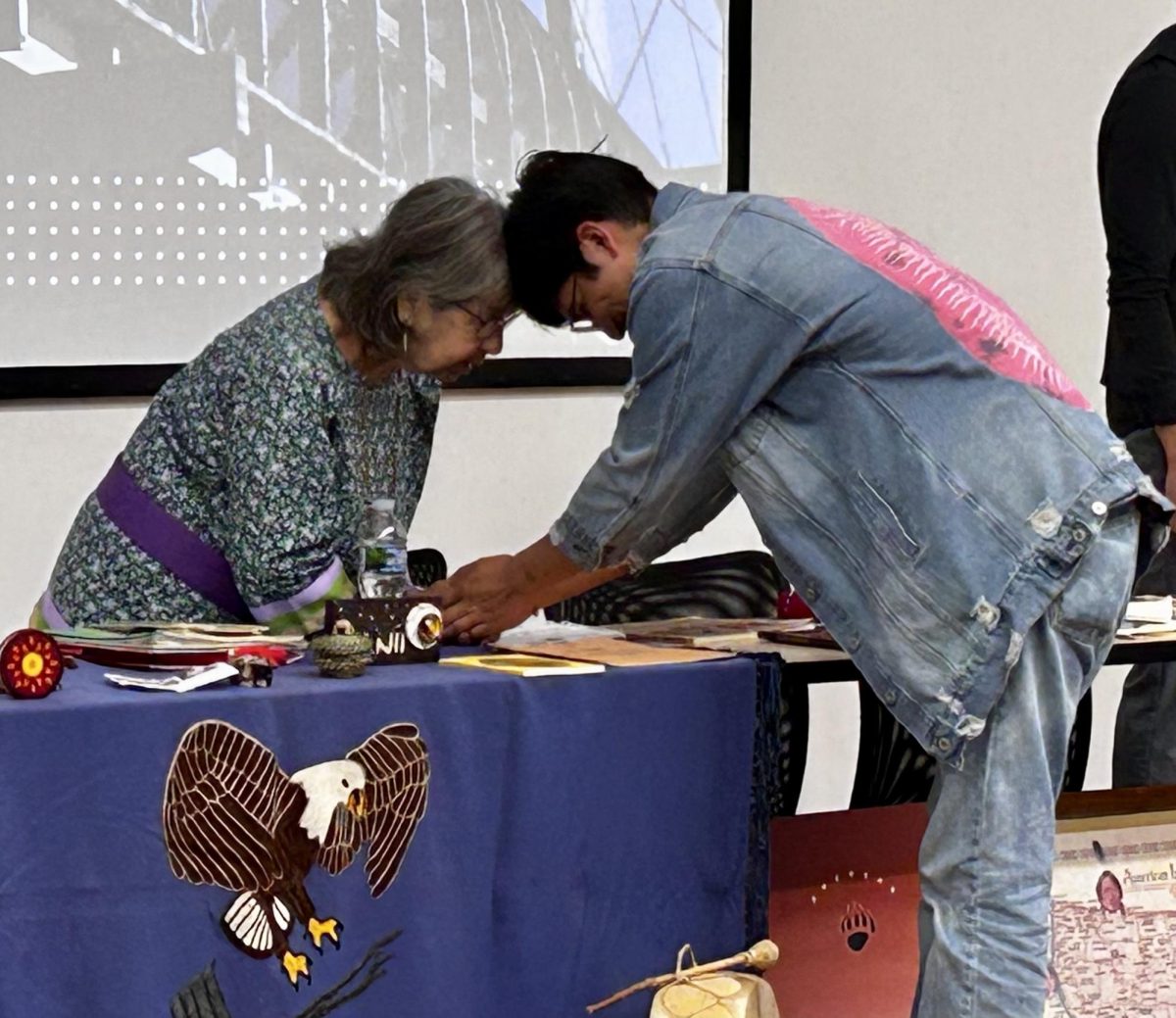At the Indigenous Peoples's Day Celebration, Grandma Mary speaks to the Great Spirit with a student.