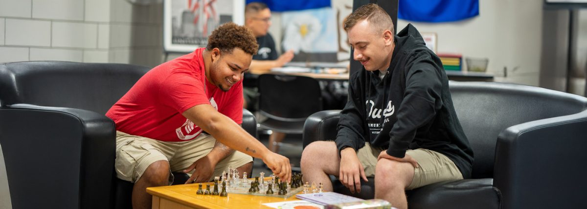 Two students playing chess at Veterans Services at Owens Community College.